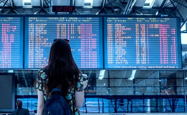 Woman looking at travel boards